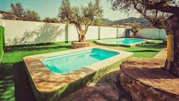Una piscina al aire libre, tumbonas
