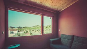 Una habitación con un ventanal grande, techo de madera y un sofá.