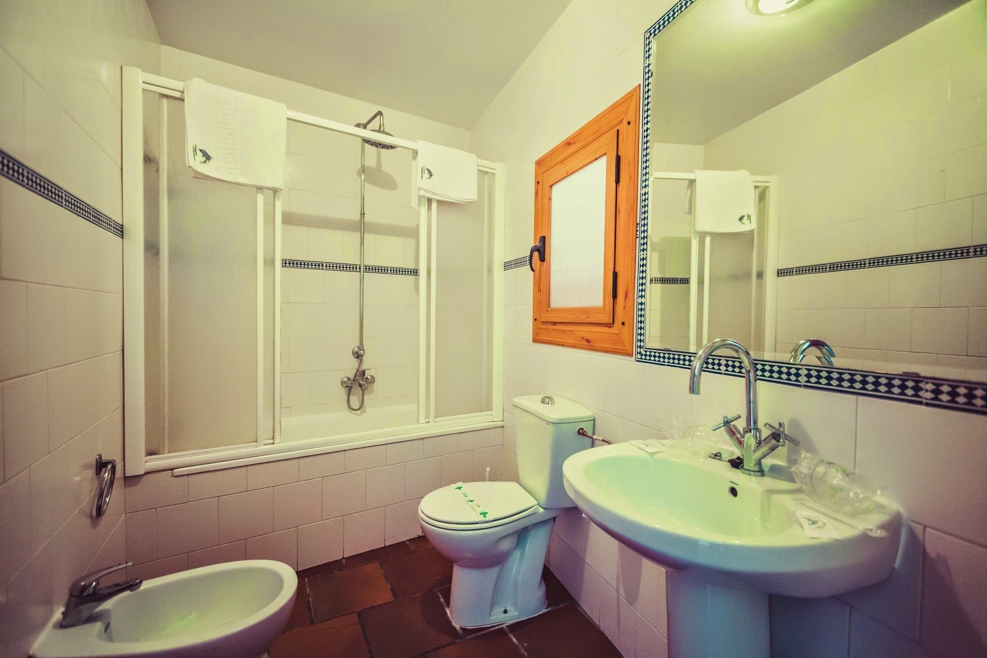 A bathroom with a bathtub, a toilet, a bidet, and a sink.