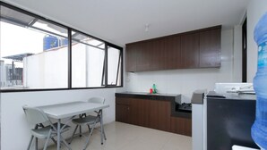 Una cocina compacta con comedor, ventanas amplias y dispensador de agua.