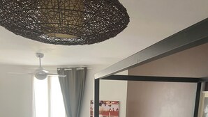 Una habitación con dos camas, una mesa de comedor y un ventilador de techo.