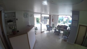 A spacious lobby with a reception desk, seating area, and a view of the outside. - Residence Zenith (Caorle)