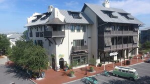 Ein zweistöckiges Gebäude mit Flachdach, großen Fenstern und einem Balkon im oberen Geschoss.