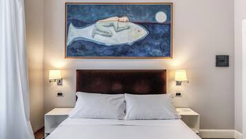 Ein Hotelzimmer mit einem großen Bett, zwei Nachttischen, einem Wandbild und einem Fenster mit Vorhängen.