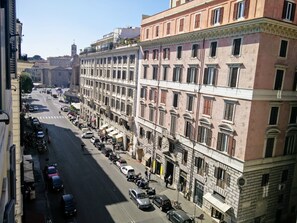 A multi-story building with a row of parked cars and motorcycles along the street. - Guest House Cavour 278 (Rome)