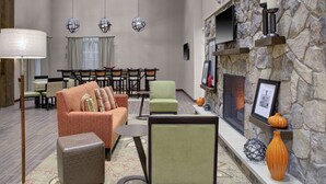 A spacious living area with a fireplace, comfortable seating, and a stone accent wall.