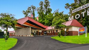 Un motel con techo rojo y un letrero que dice 'Highland Motel'.