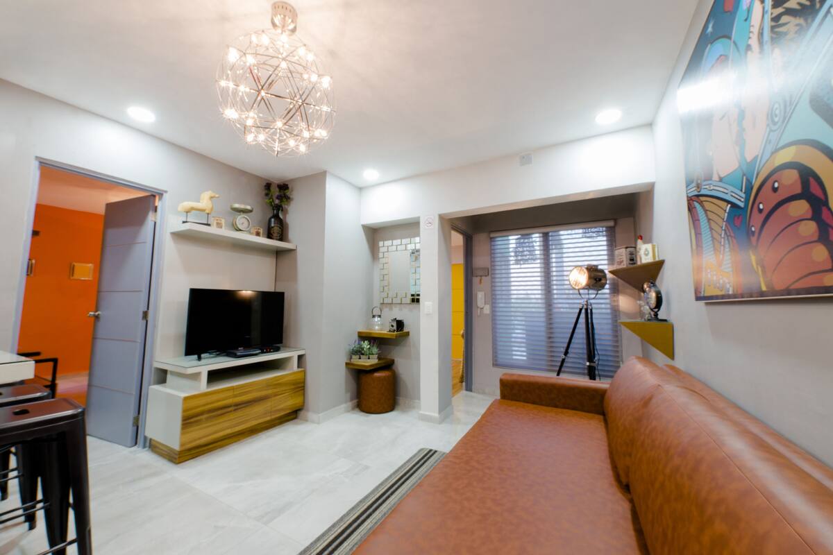 A modern living room with a TV, sofa, and decorative items.