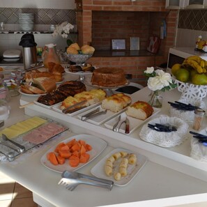 Buffet com diversos alimentos e utensílios.