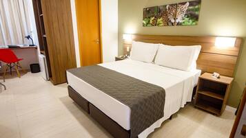 Une chambre d’hôtel comprenant un lit, des tables de chevet, un bureau et une chaise.