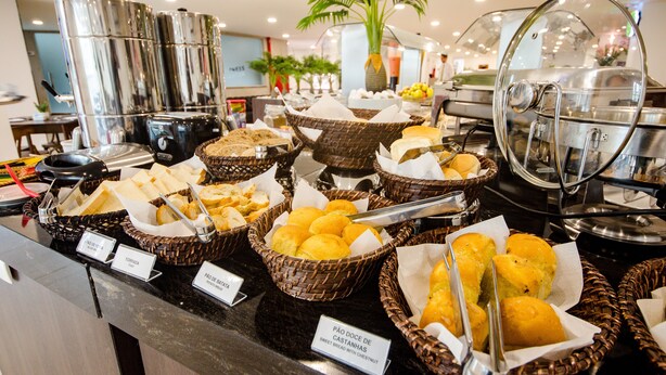 A buffet with various food items in baskets, including bread and pastries. - Bristol Umarizal Belem (Belém)