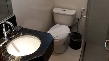 A bathroom with a sink, toilet, and shower.