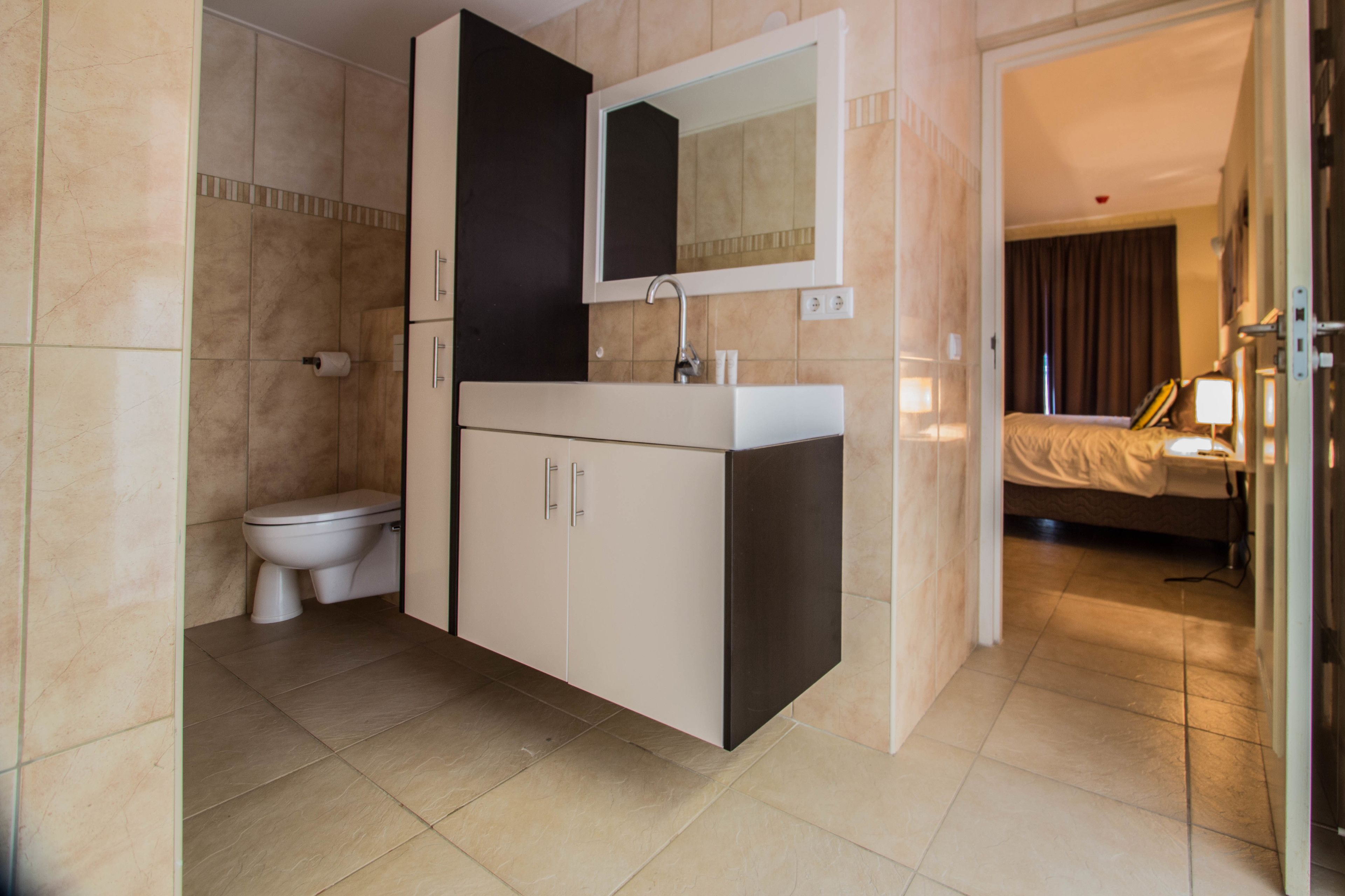 Une salle de bain moderne équipée de toilettes, d’un lavabo et d’un miroir.