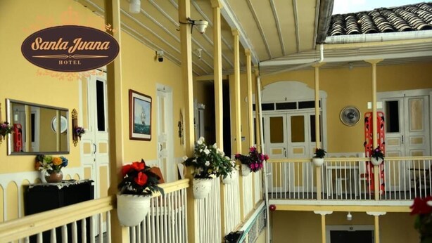 A hotel with a yellow facade, white railings, and multiple balconies. - Hotel Santa Juana (Santa Rosa de Cabal)