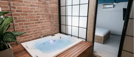 A modern bathroom with a wooden vanity, a freestanding bathtub, and a glass shower enclosure.