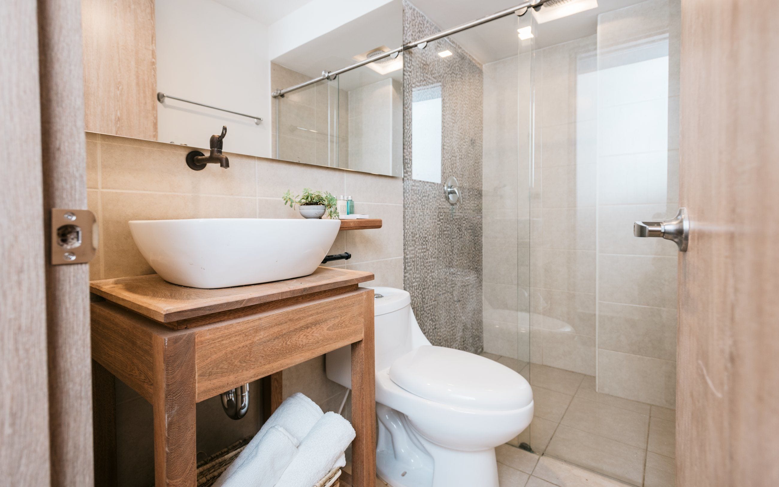 Une salle de bain moderne avec une baignoire sur pieds, des toilettes et une douche séparée par des parois en verre.