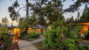 A residential property with a pathway leading to a house, surrounded by lush greenery and trees. - Inn at Buckhorn Cove (Little River)