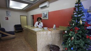 A reception area with a marble counter, a Christmas tree, and a framed picture on the wall. - Sylva Link Hotel (Lagos)