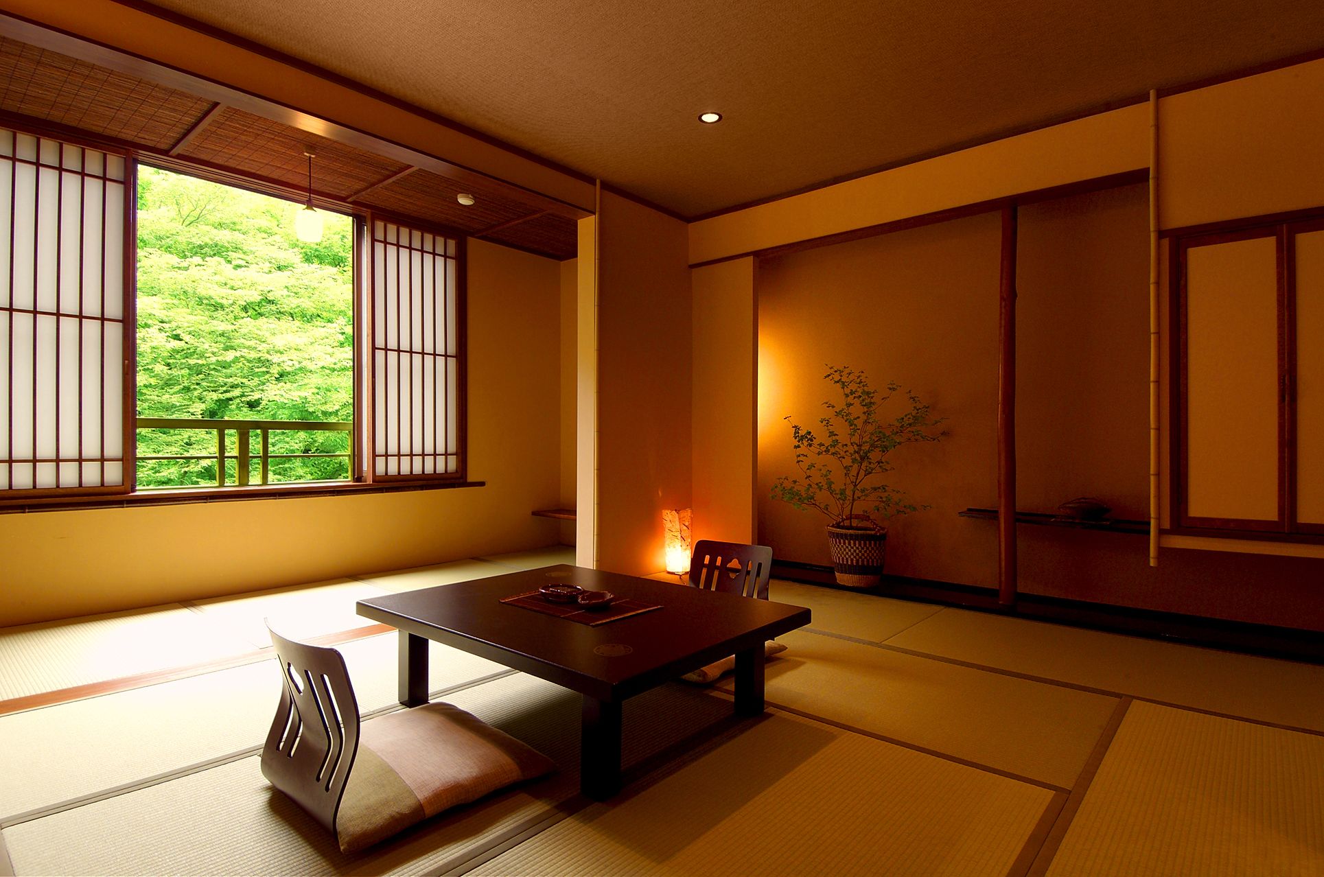 A traditional Japanese room with tatami flooring, a low table, and sliding doors.