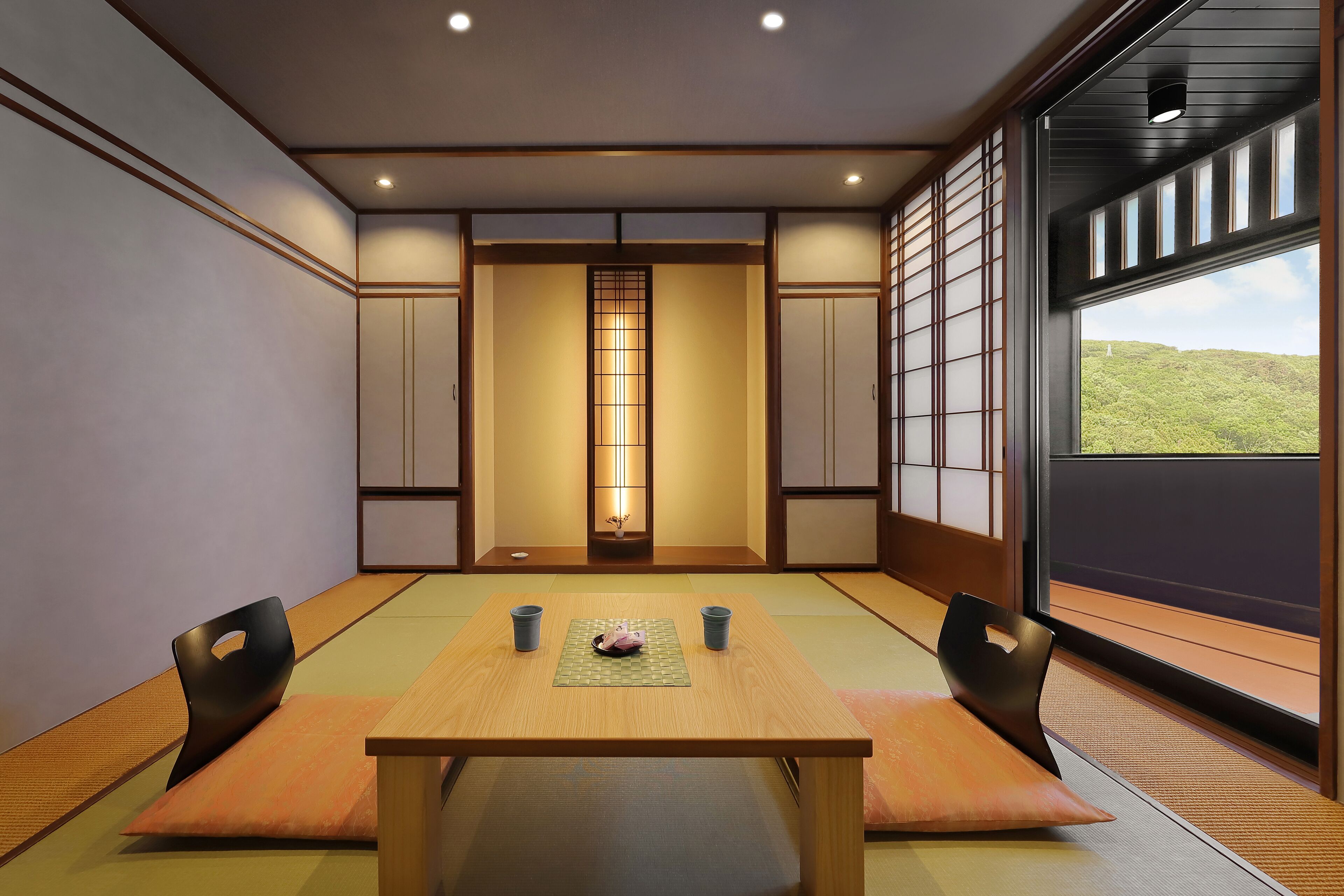Een traditionele Japanse kamer met tatami vloeren, een lage tafel met kussens en schuifdeuren.