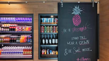 Exhibición de bebidas con diversas opciones y una pizarra con un dibujo de piña y texto.