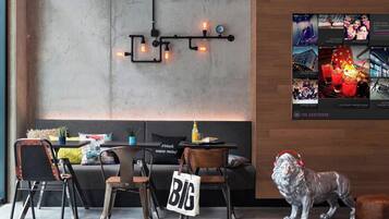 Un interior moderno con un sofá, sillas, una mesa, una estatua decorativa de un león y un aplique de pared.