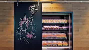 Una presentación de alimentos con comidas envasadas y una pizarra con un dibujo y texto.