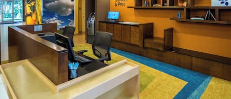 A reception area with a computer, a telephone, and a sign that reads "Connect & Print".