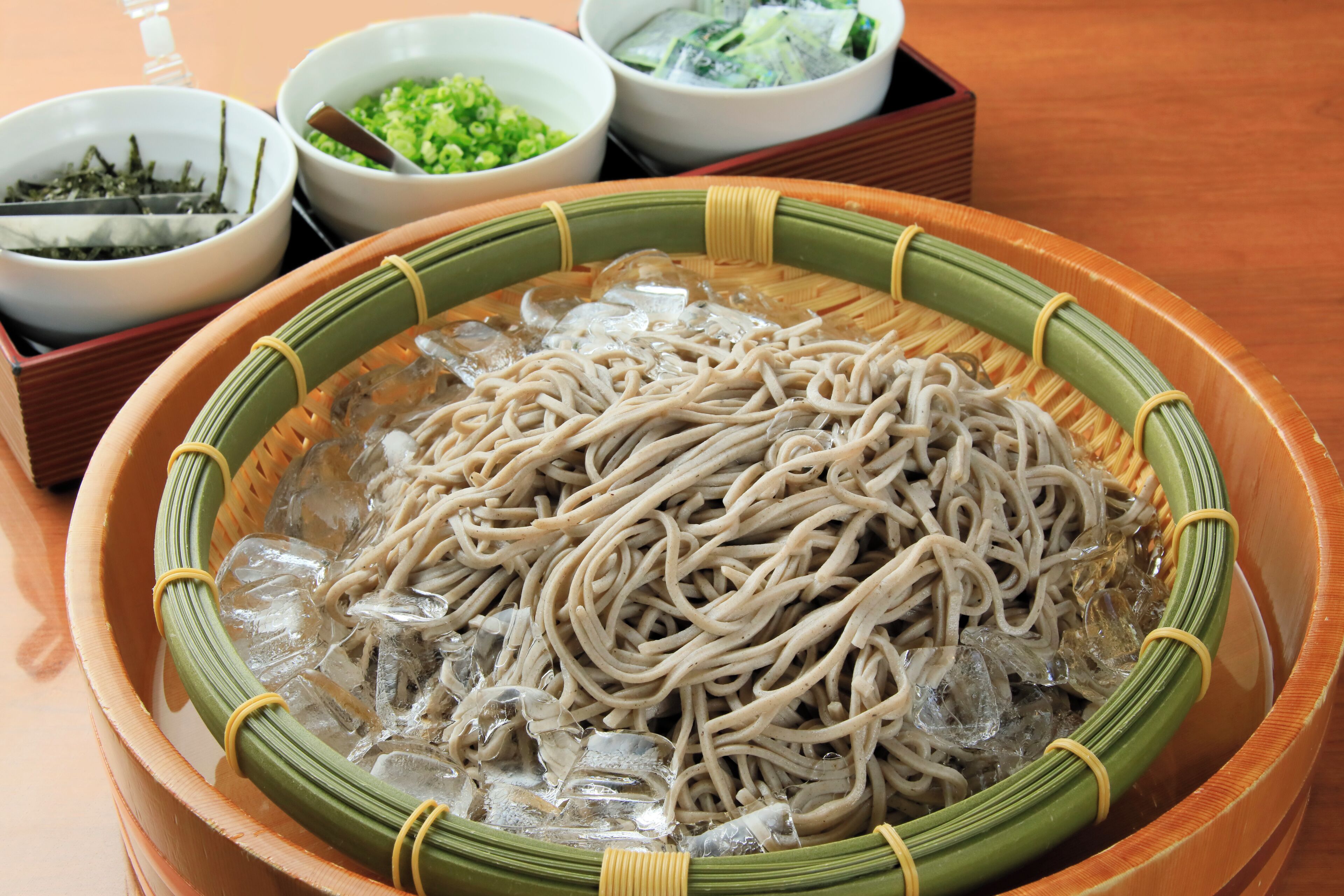 A bowl of noodles with various side dishes.