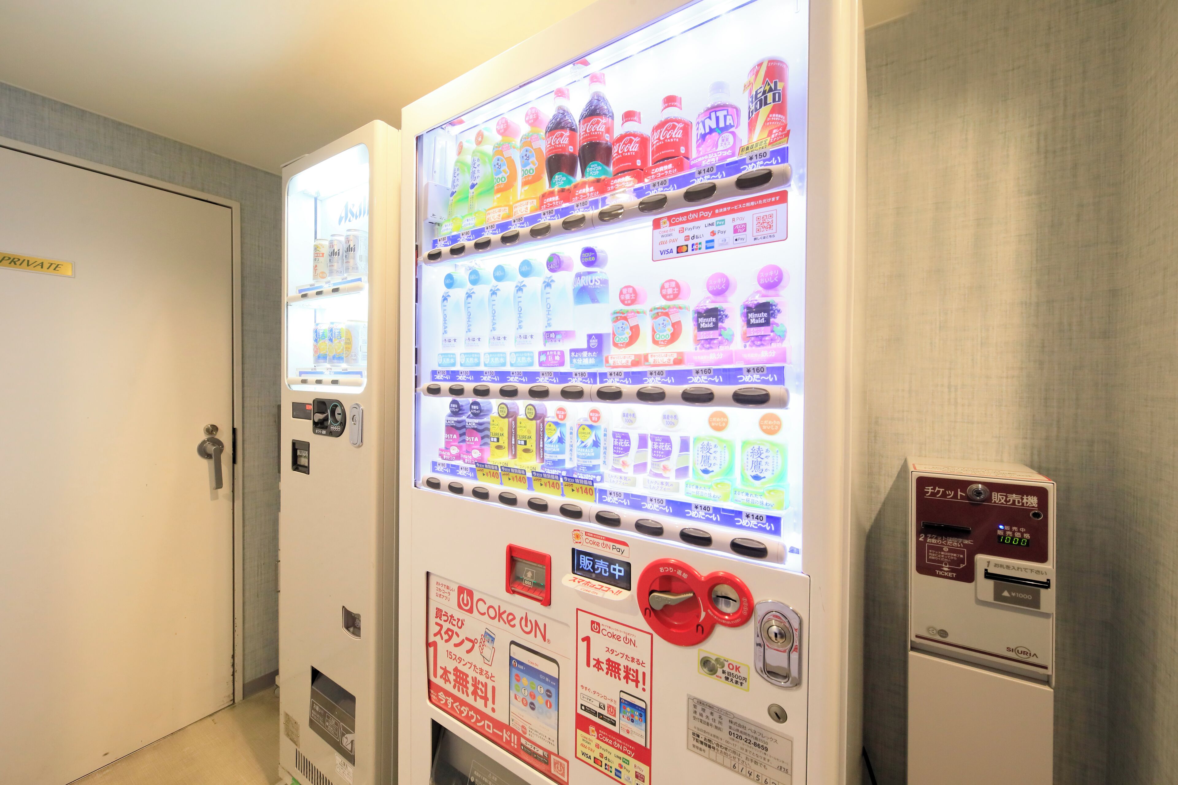 A vending machine with various drinks and snacks, a payment terminal, and a sign indicating it is a private area.