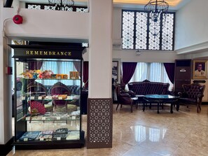 A hotel lobby with a 'REMEMBRANCE' shop, leather sofas, and a chandelier. - Siam Champs Elyseesi Unique Hotel (Bangkok)