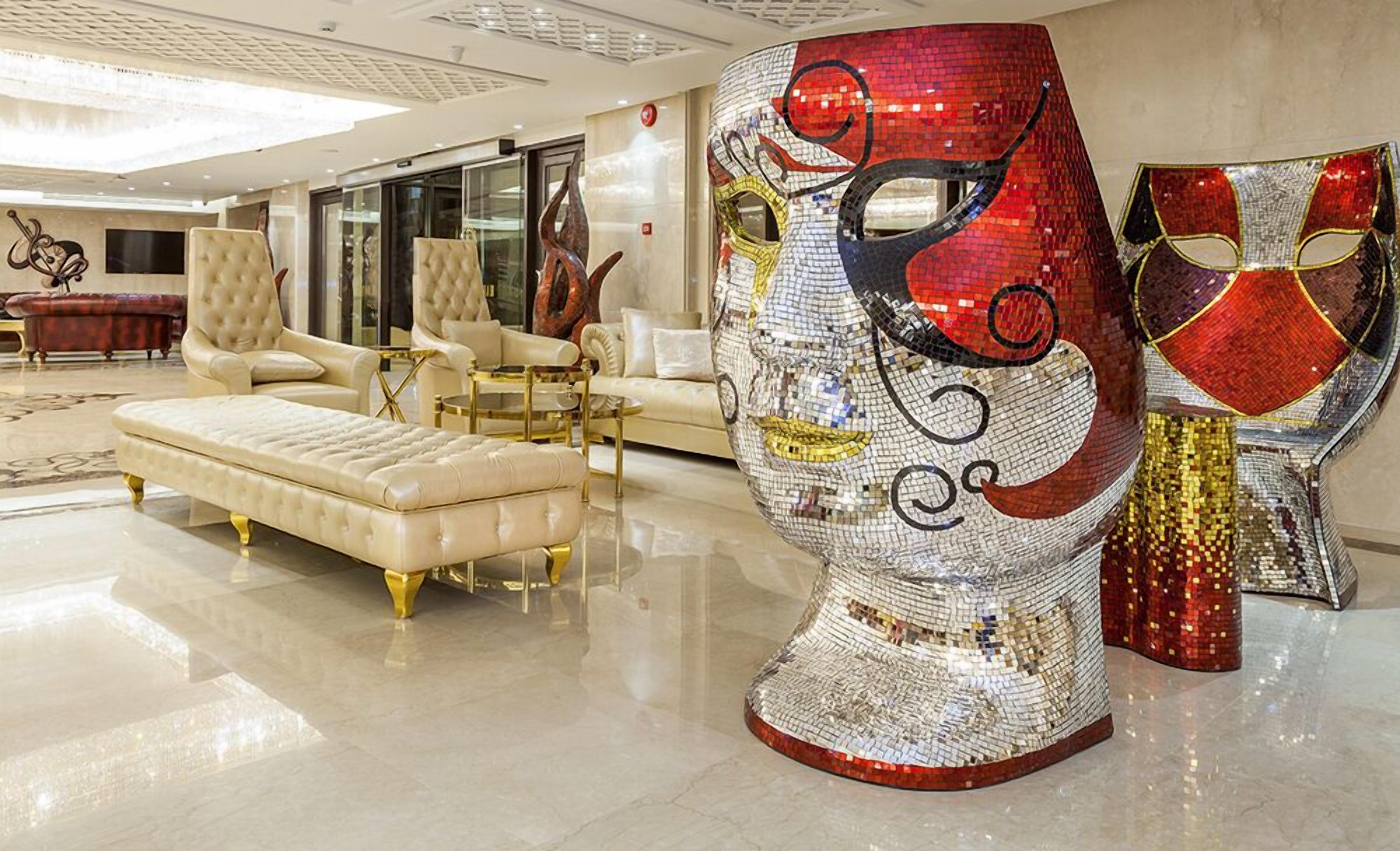 Un hall de lujo con asientos mullidos, una gran escultura decorativa para la cabeza y una decoración moderna.