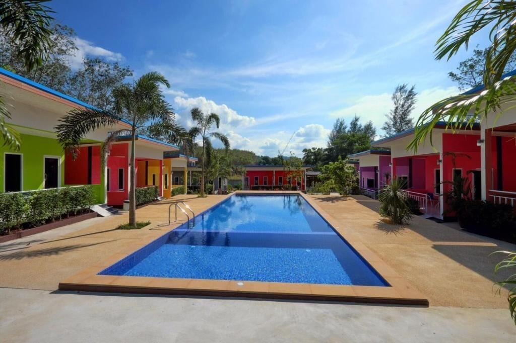 A swimming pool surrounded by colorful buildings with a clear sky.
