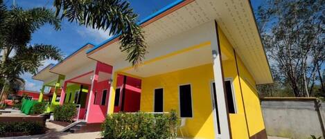 Un edificio colorido con techo plano y una zona de entrada cubierta.