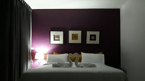 Een hotelkamer met een bed, een hoofdeinde en drie ingelijste foto's aan de muur.