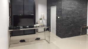 Een moderne keuken met een zwart kastje, een wit aanrecht en een zwarte muur met een bakstenen patroon.