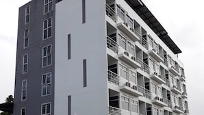 Een meerlaags gebouw met een modern architectonisch ontwerp, met balkons en grote ramen.