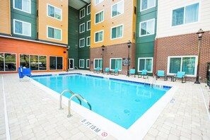 A swimming pool with a 5 ft 15 m depth marker, surrounded by lounge chairs and a brick building. - Residence Inn Columbia West/Lexington (West Columbia)