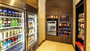 A corridor with refrigerated beverage dispensers and snack shelves. - Residence Inn Columbia West/Lexington (West Columbia)