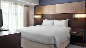 Una habitación de hotel con cama, mesitas de noche, escritorio y televisor.
