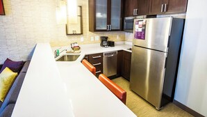 A compact kitchen with a dishwasher, a refrigerator, and a coffee maker. - Residence Inn Columbia West/Lexington (West Columbia)