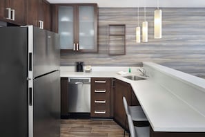 A modern kitchen with stainless steel appliances, wooden cabinets, and a built-in dishwasher. - Residence Inn Columbia West/Lexington (West Columbia)