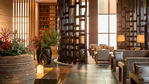 A modern lobby with wooden partitions, seating areas, and a fireplace. - AOLUGUYA · The Unbound Collection by Hyatt (Harbin)