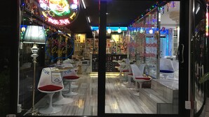 L’intérieur d’un café, avec un panneau néon, un comptoir et un espace salon.