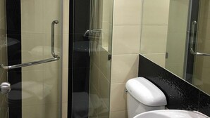 Une salle de bain moderne avec une douche à parois de verre, des toilettes blanches et un lavabo.