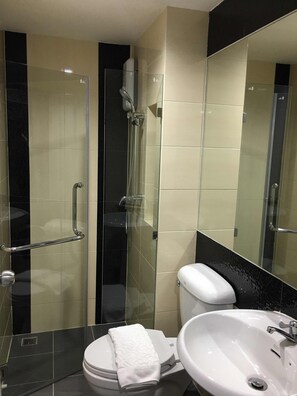 Une salle de bain moderne avec une douche à parois de verre, des toilettes blanches et un lavabo.