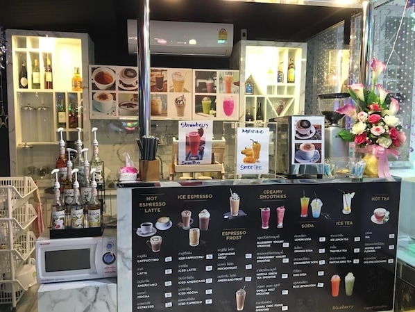 Un café où l’on peut consulter un tableau affichant les différentes boissons proposées, ainsi qu’un assortiment de machines à expresso.