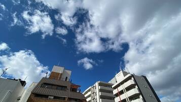 A multi-story building with a flat roof and a visible antenna on the top.