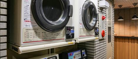 A laundry facility with two washing machines and a control panel.