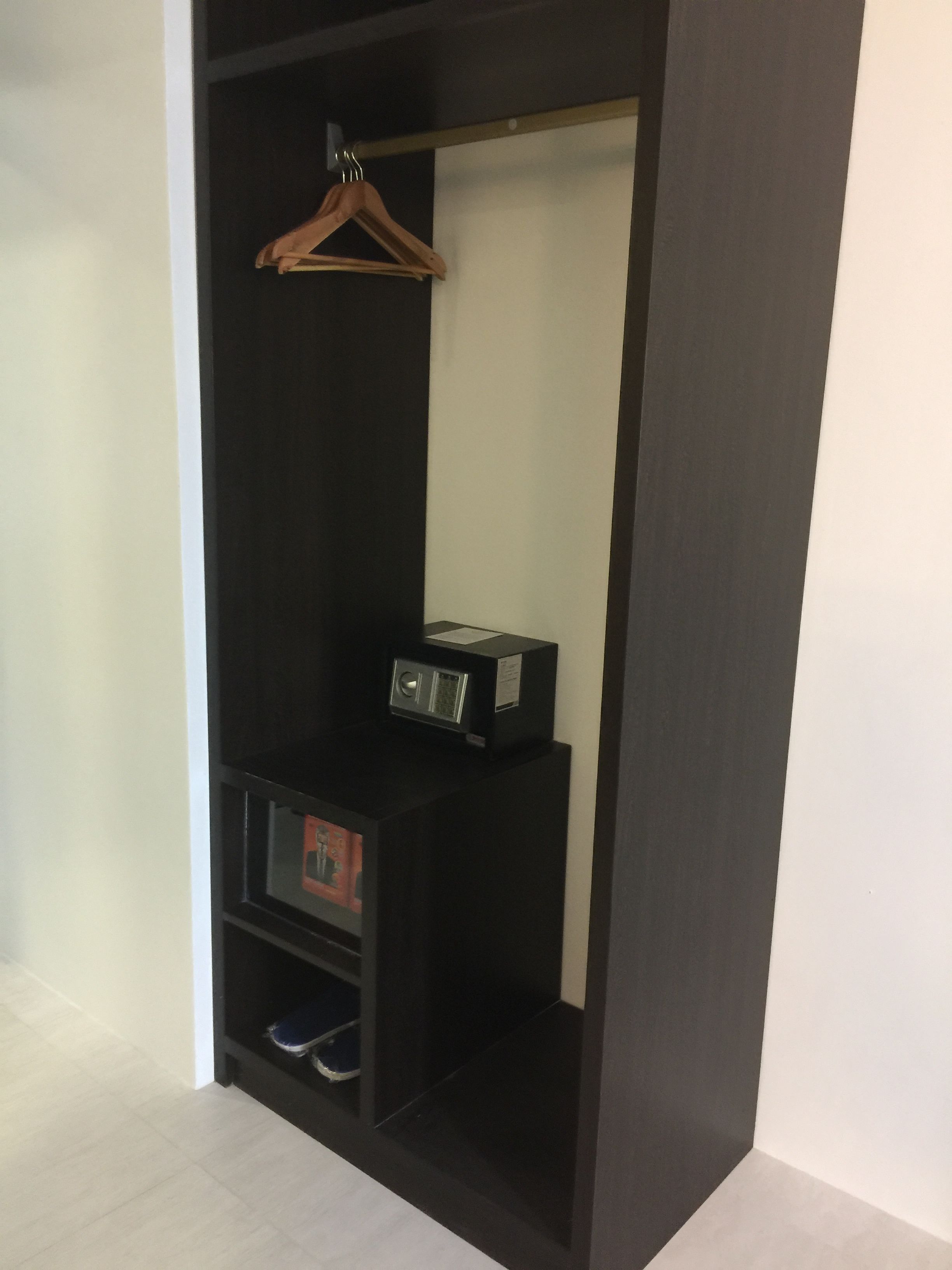 A walk-in closet with a hanging rod, shelves, and a shoe rack.